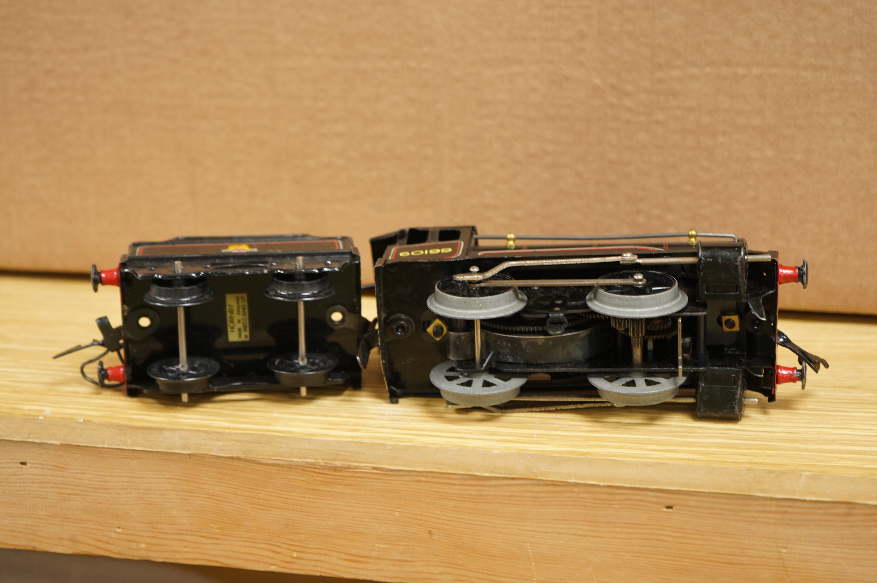 A collection of 0 gauge Hornby tinplate clockwork railway, including four BR locomotives, 17 freight wagons and four wheel coaches, together with a station building, signal cabin, and Goods depot (missing base), plus a f